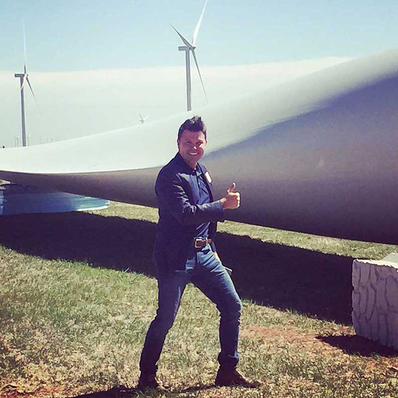 Jim standing in front of large windmill parts on the ground