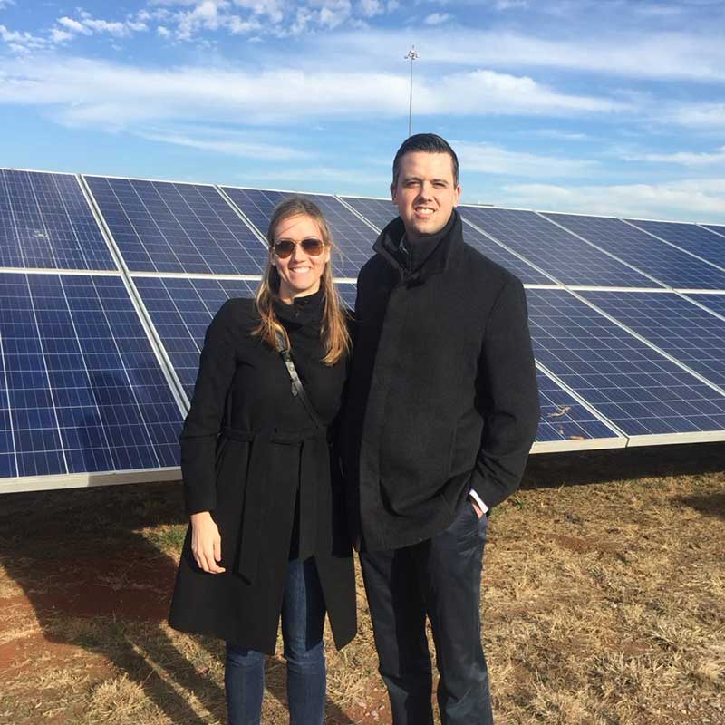 team members in front of a solar panel